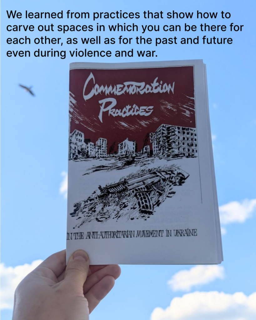 There is a picture of person holding a printed paper zine in their hand with a blue sky in the background. The cover of the zine is white and red. it says Commemoration practices in the anti-authoritarian movement in Ukraine.