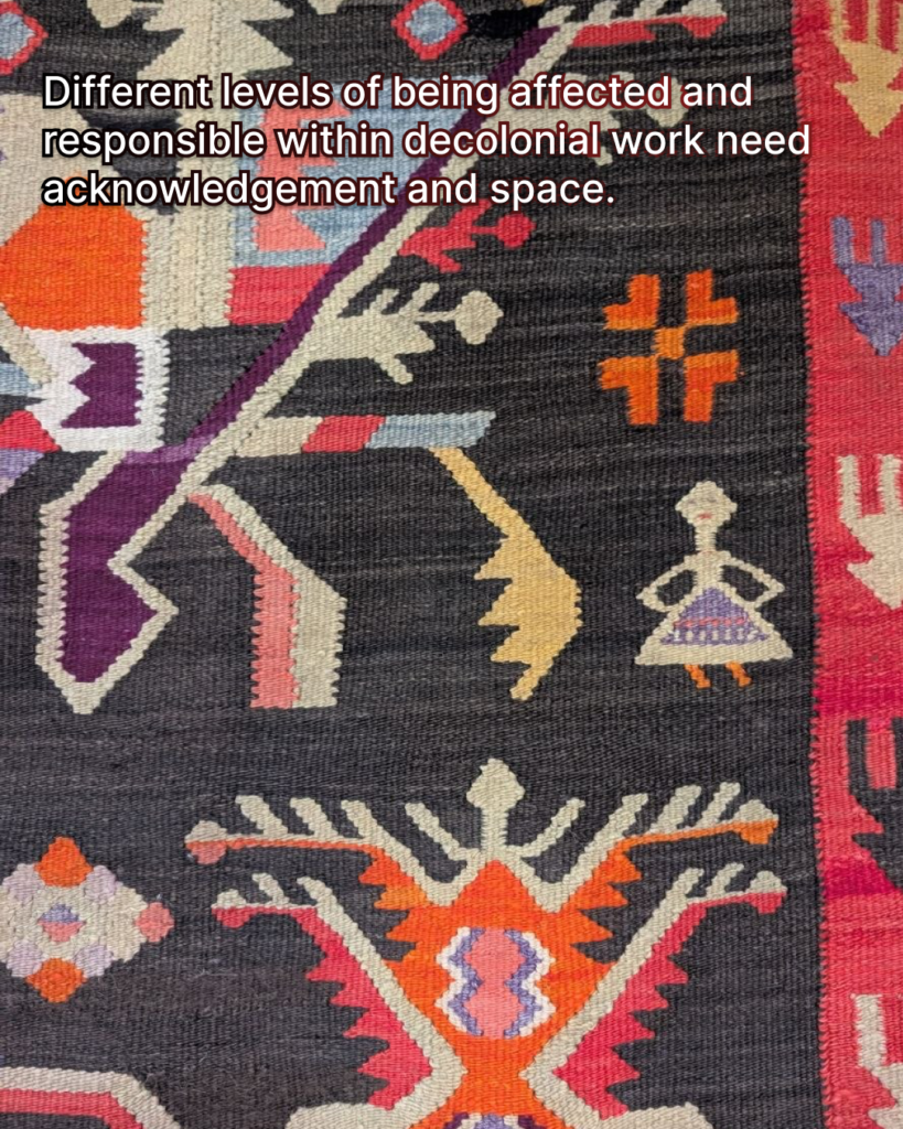There is a fragment of the Moldovan carpet shown in the picture. There are colourful figures and ornaments. One figure of a person holding their hands on the hips is visible. There is a text I the background: different levels of being affected and responsible within decolonial work need acknowledgement and space.