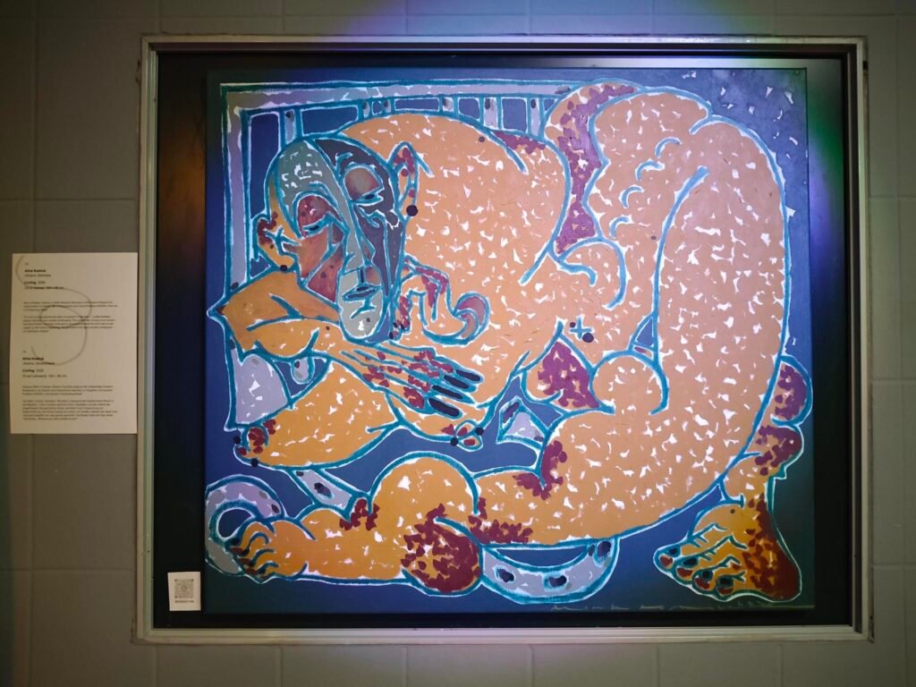 The painting is executed in oil. It depicts an abstract figure in shades of brown and orange against a dark blue background. The figure is contorted and rendered in surreal proportions, appearing as though it has been squeezed into the picture. The figure’s head is in the top left-hand corner, its back extends to the top right-hand corner, one leg stretches diagonally across the picture towards the bottom left, whilst the other leg is compressed and the foot ends in the bottom right-hand corner of the picture. The elongated face has heavy eyelids and looks exhausted, and the mouth is not smiling. The face hovers slightly above the curled-up hands. The hands are elongated and look more like claws than fingers. Individual vertebrae are visible along the spine. There are red splashes of colour at the joints all over the body, giving the impression that they are in pain. The joints also appear knobbly and swollen. Behind the figure, in grey, is a shape that looks like cage bars and a curved shape with dots and a ring, which resemble a chain in a zoo.